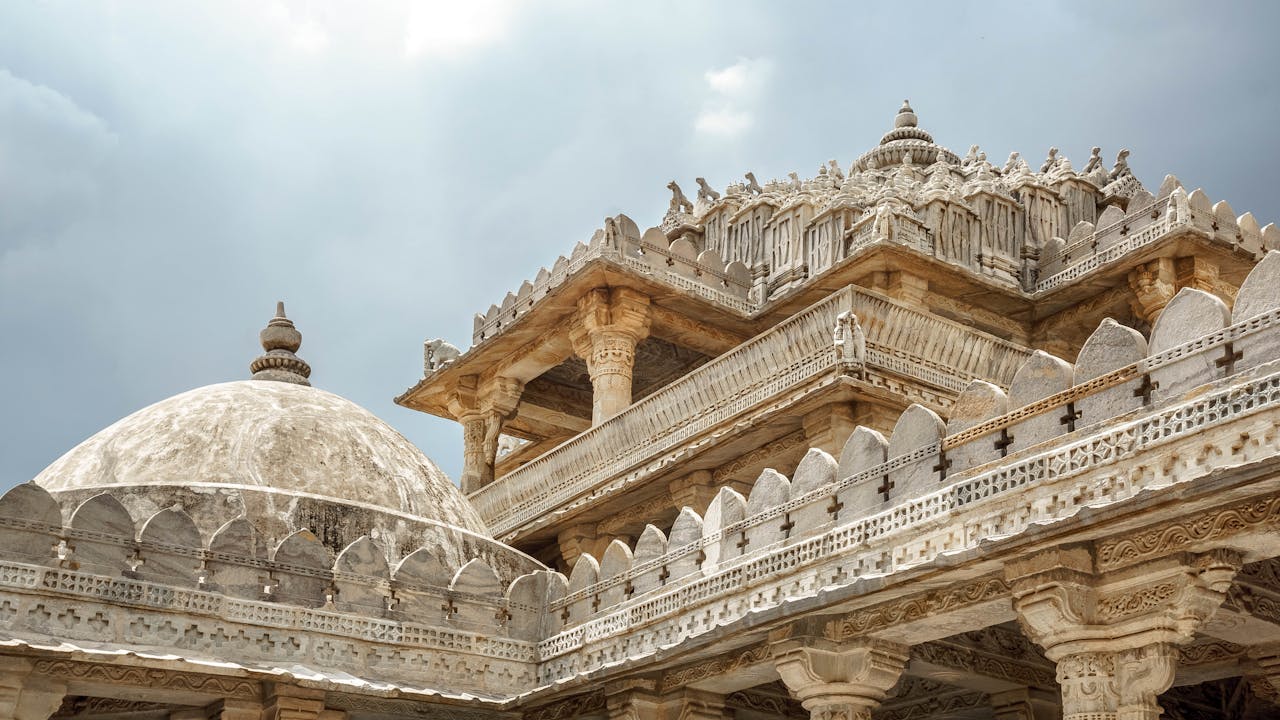 Stunning view of the intricate carvings on the Ranakpur Jain Temple in Rajasthan, India, under a cloudy sky.