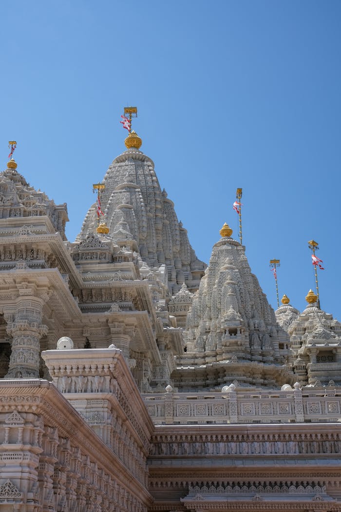 Intricate marble architecture of a temple under a clear blue sky, showcasing cultural elegance.
